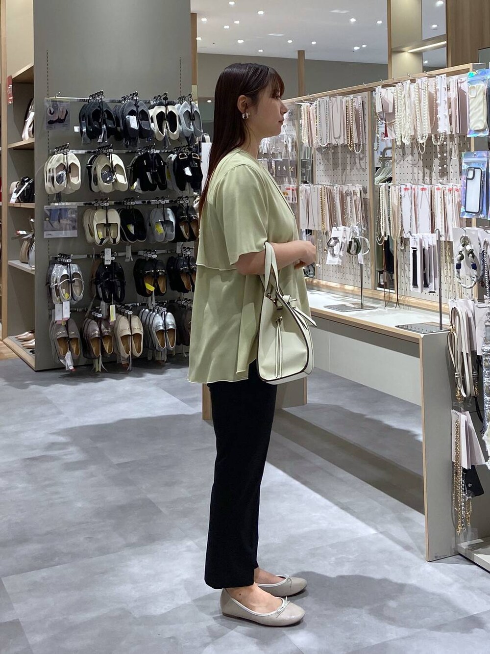ホワイト系のバレエシューズ、ホワイト系のショルダーバッグ、イエロー系のシャツ/ブラウスを着用したレディースの夏コーディネートの4枚目の写真