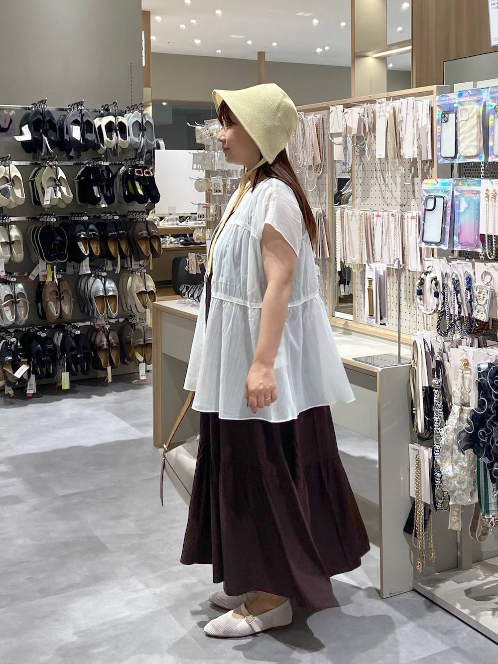 ホワイト系のショルダーバッグ、ホワイト系のパンプス、ホワイト系のシャツ/ブラウスを着用したレディースの夏コーディネートの2枚目の写真