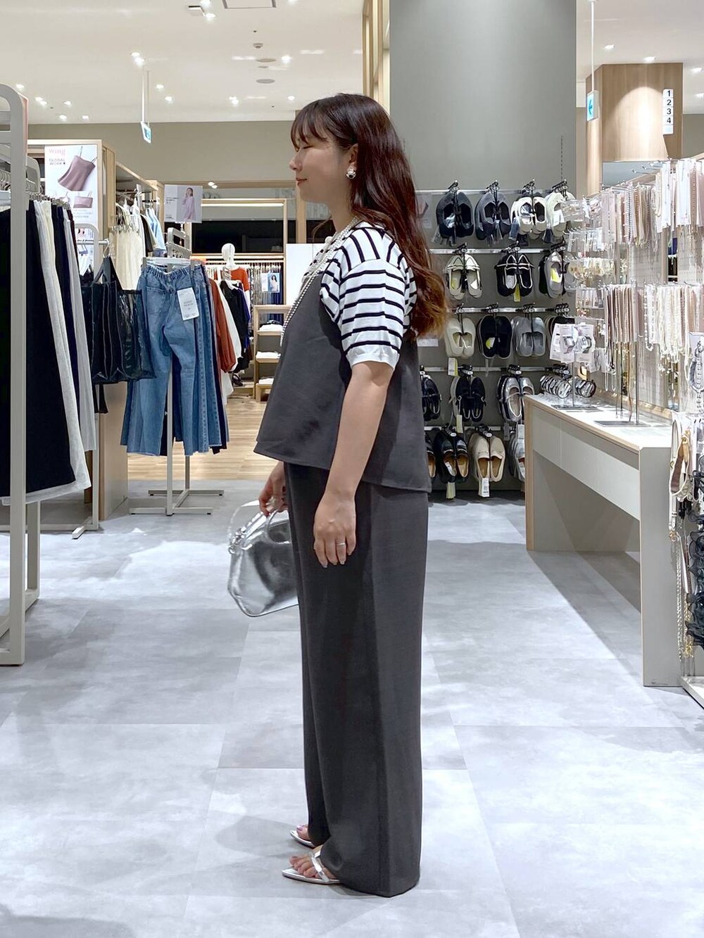 シルバー系のショルダーバッグ、ホワイト系のTシャツ/カットソー、シルバー系のサンダルを着用したレディースの夏コーディネートの2枚目の写真