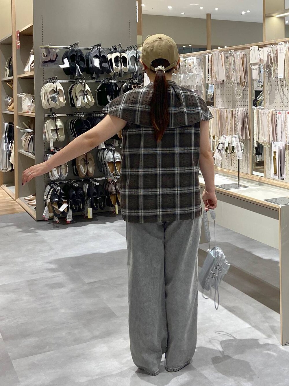 グレー系のデニムパンツ、シルバー系のショルダーバッグ、シルバー系のサンダルを着用したレディースの夏コーディネートの3枚目の写真