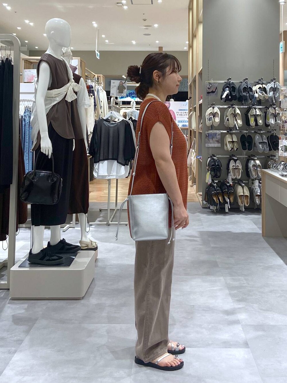 ブラウン系のTシャツ/カットソー、シルバー系のショルダーバッグ、ブラウン系のデニムパンツを着用したレディースの夏コーディネートの3枚目の写真