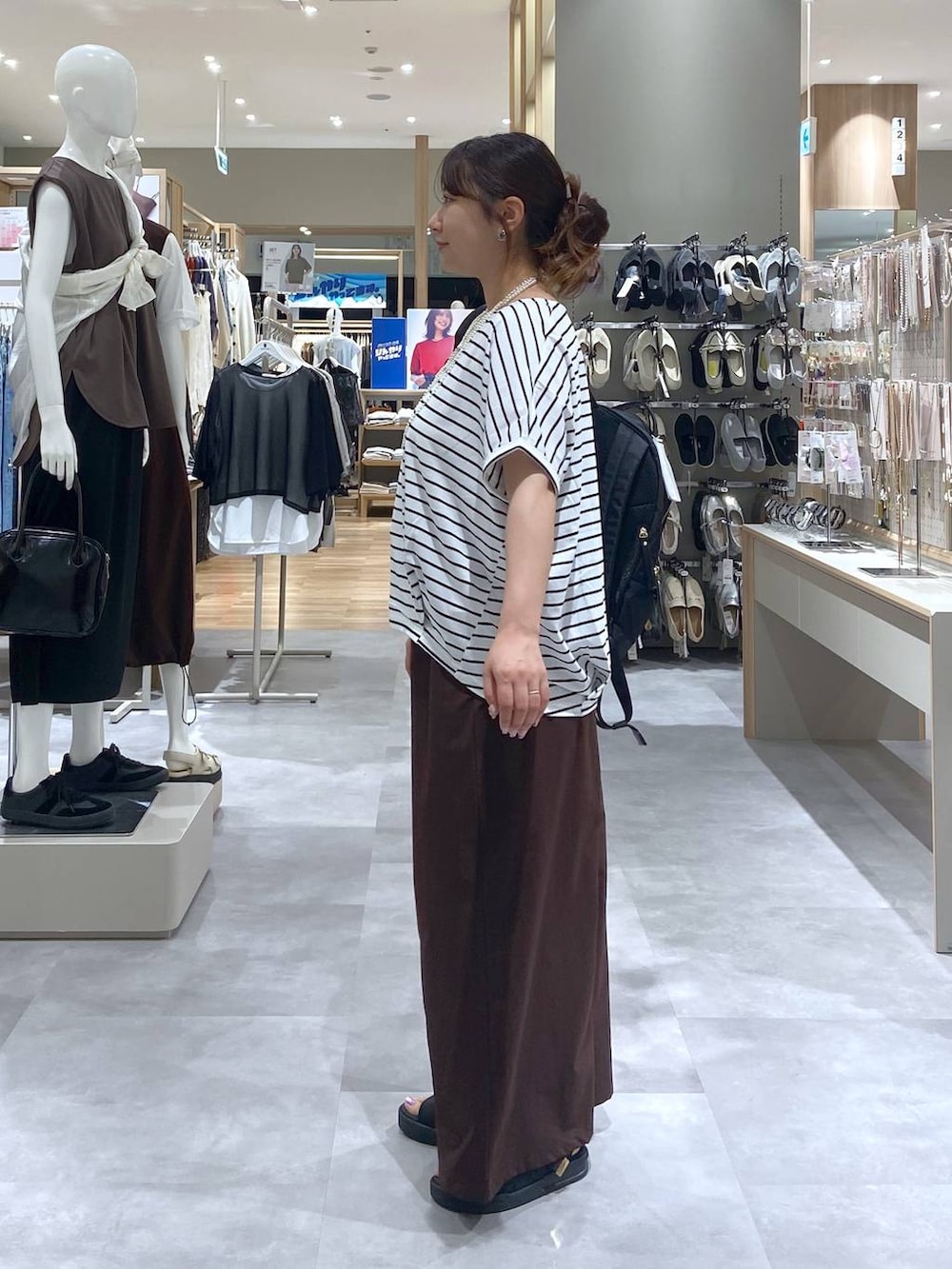 ブラック系のバックパック/リュック、ブラック系のサンダル、ホワイト系のTシャツ/カットソーを着用したレディースの夏コーディネートの2枚目の写真