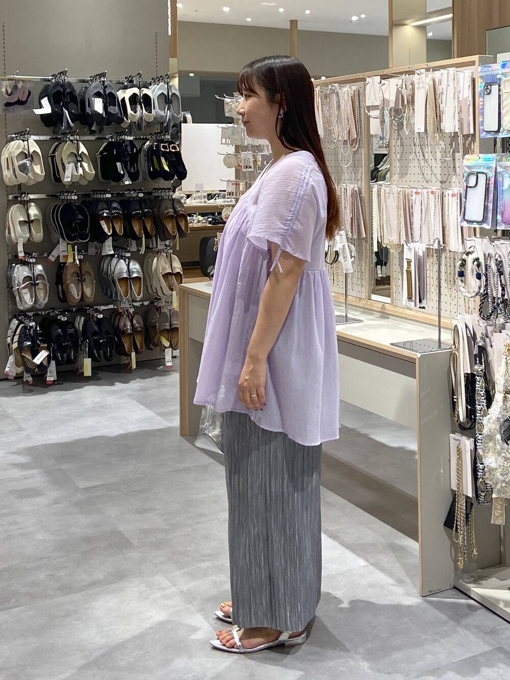 シルバー系のショルダーバッグ、パープル系のシャツ/ブラウス、シルバー系のサンダルを着用したレディースの夏コーディネートの2枚目の写真