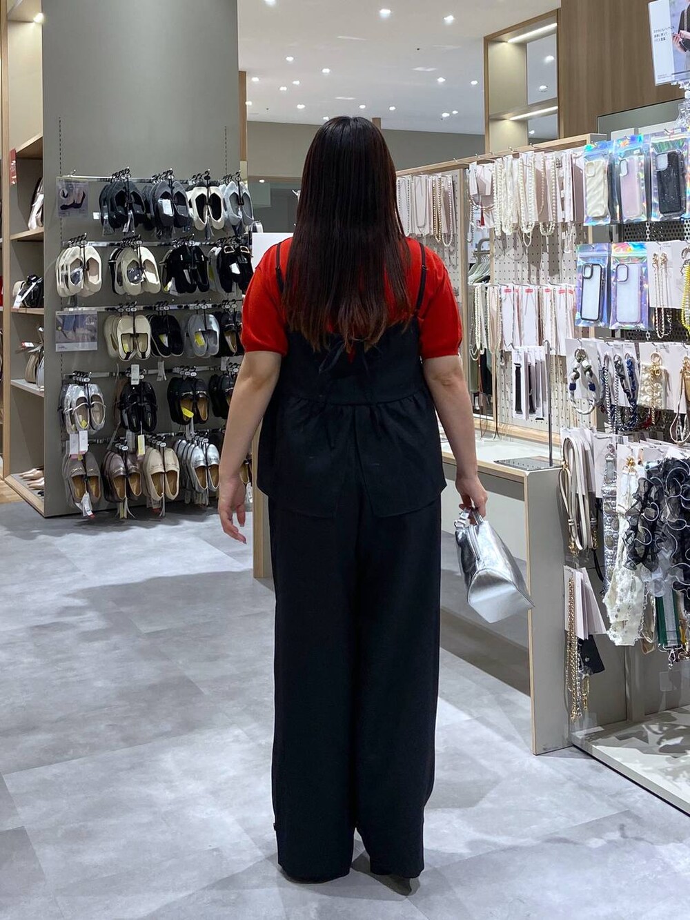 シルバー系のショルダーバッグ、レッド系のTシャツ/カットソー、ブラック系のサンダルを着用したレディースの夏コーディネートの3枚目の写真