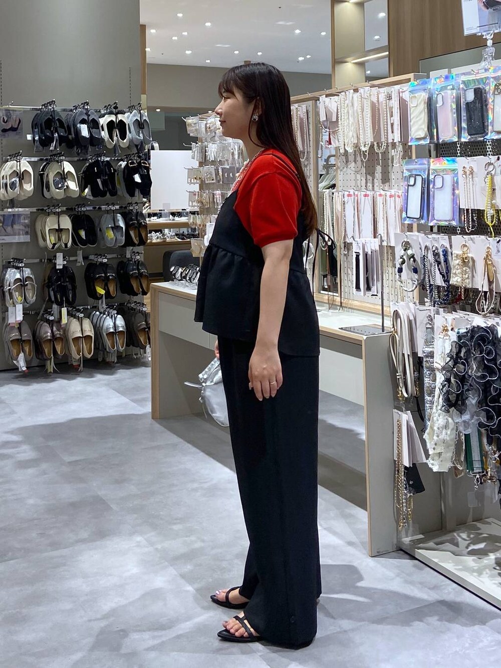 シルバー系のショルダーバッグ、レッド系のTシャツ/カットソー、ブラック系のサンダルを着用したレディースの夏コーディネートの2枚目の写真