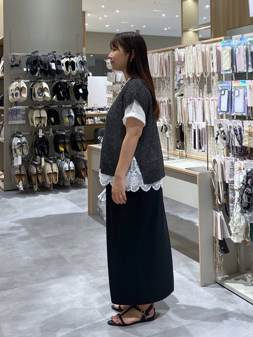 シルバー系のショルダーバッグ、ブラック系のサンダル、ホワイト系のTシャツ/カットソーを着用したレディースの夏コーディネートの2枚目の写真
