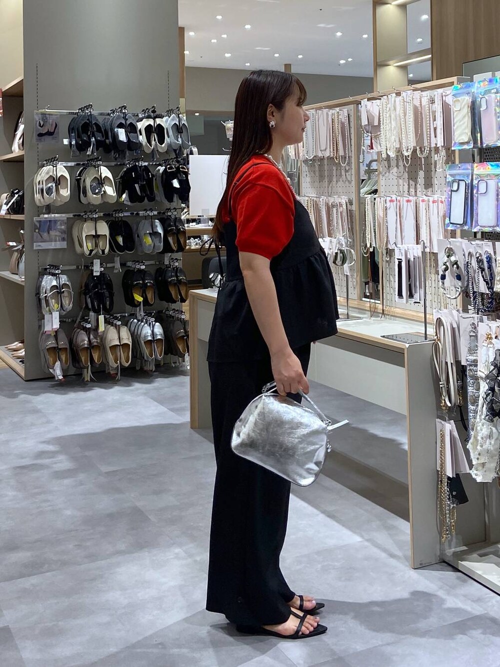 シルバー系のショルダーバッグ、レッド系のTシャツ/カットソー、ブラック系のサンダルを着用したレディースの夏コーディネートの4枚目の写真