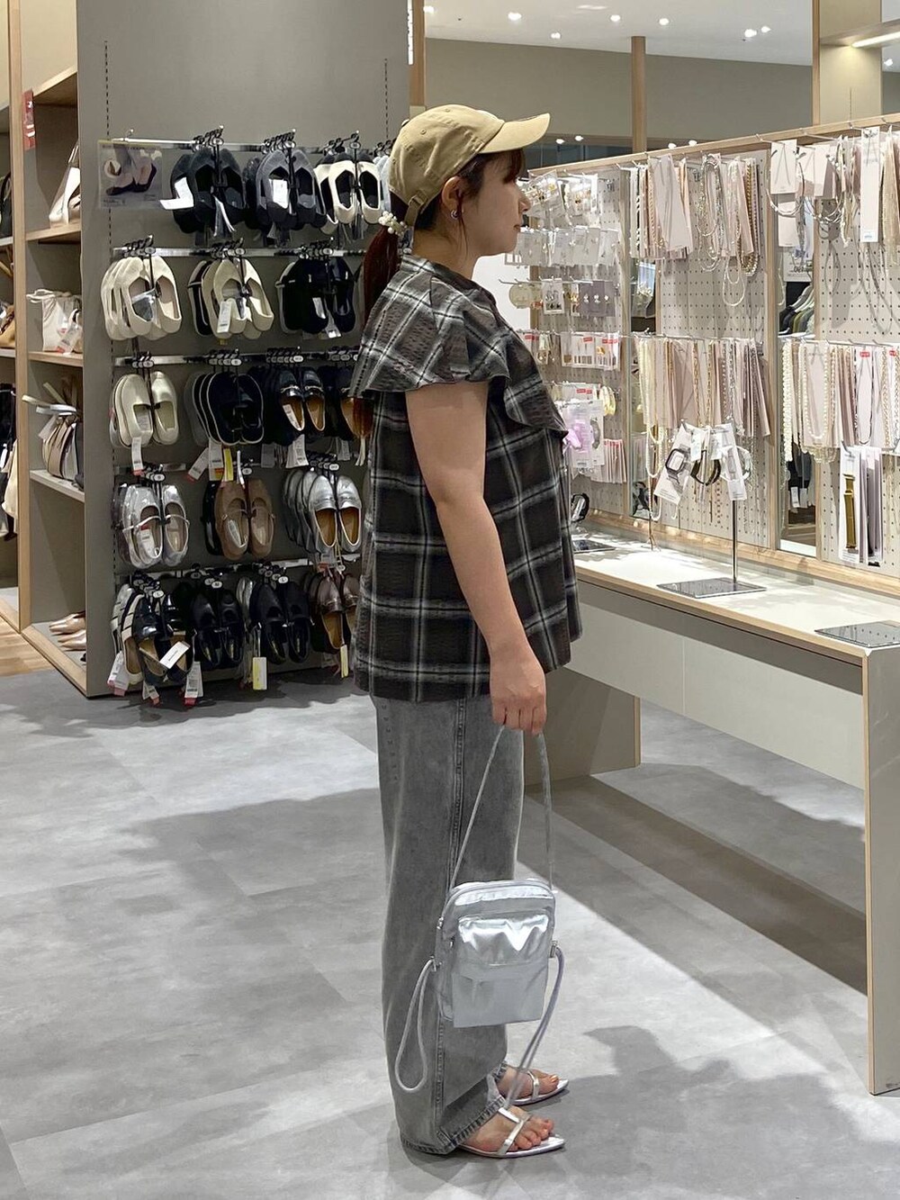 グレー系のデニムパンツ、シルバー系のショルダーバッグ、シルバー系のサンダルを着用したレディースの夏コーディネートの4枚目の写真