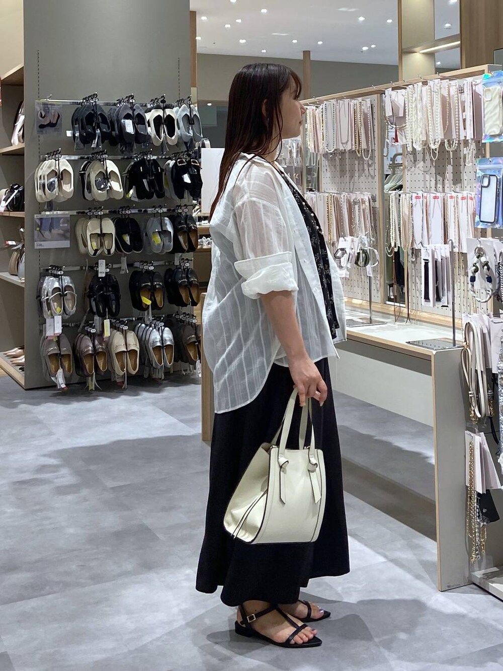 ホワイト系のショルダーバッグ、ホワイト系のシャツ/ブラウス、ブラック系のサンダルを着用したレディースの夏コーディネートの4枚目の写真