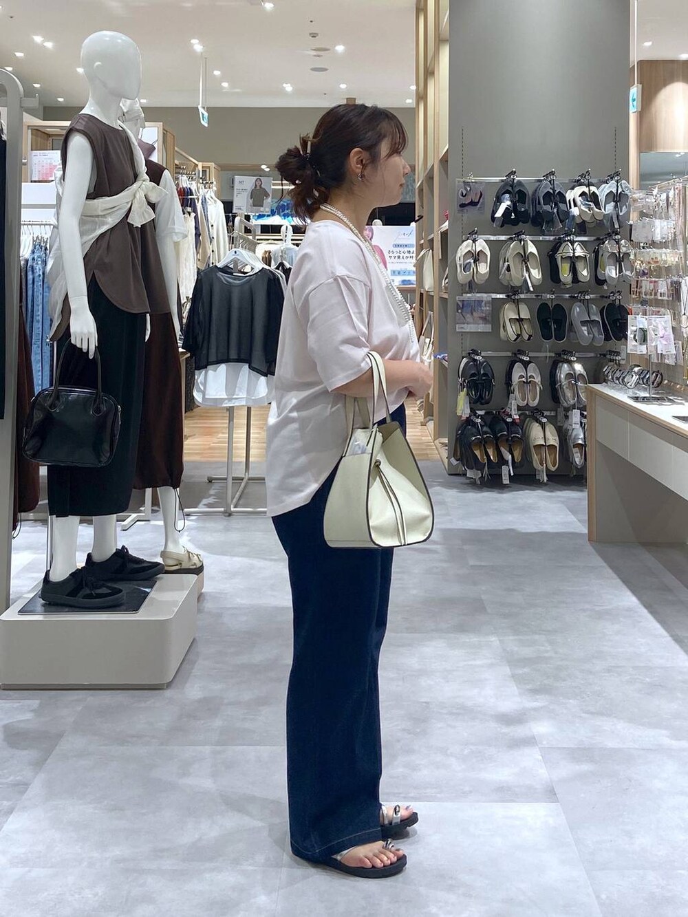 ホワイト系のショルダーバッグ、ピンク系のTシャツ/カットソー、ブルー系のデニムパンツを着用したレディースの夏コーディネートの4枚目の写真