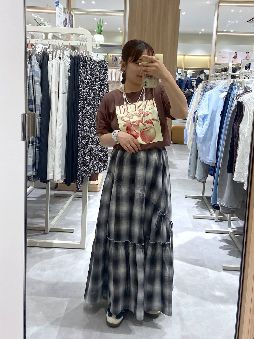 ブラック系のスカート、ブルー系のシュシュ、シルバー系のネックレスを着用したレディースの夏コーディネートの3枚目の写真