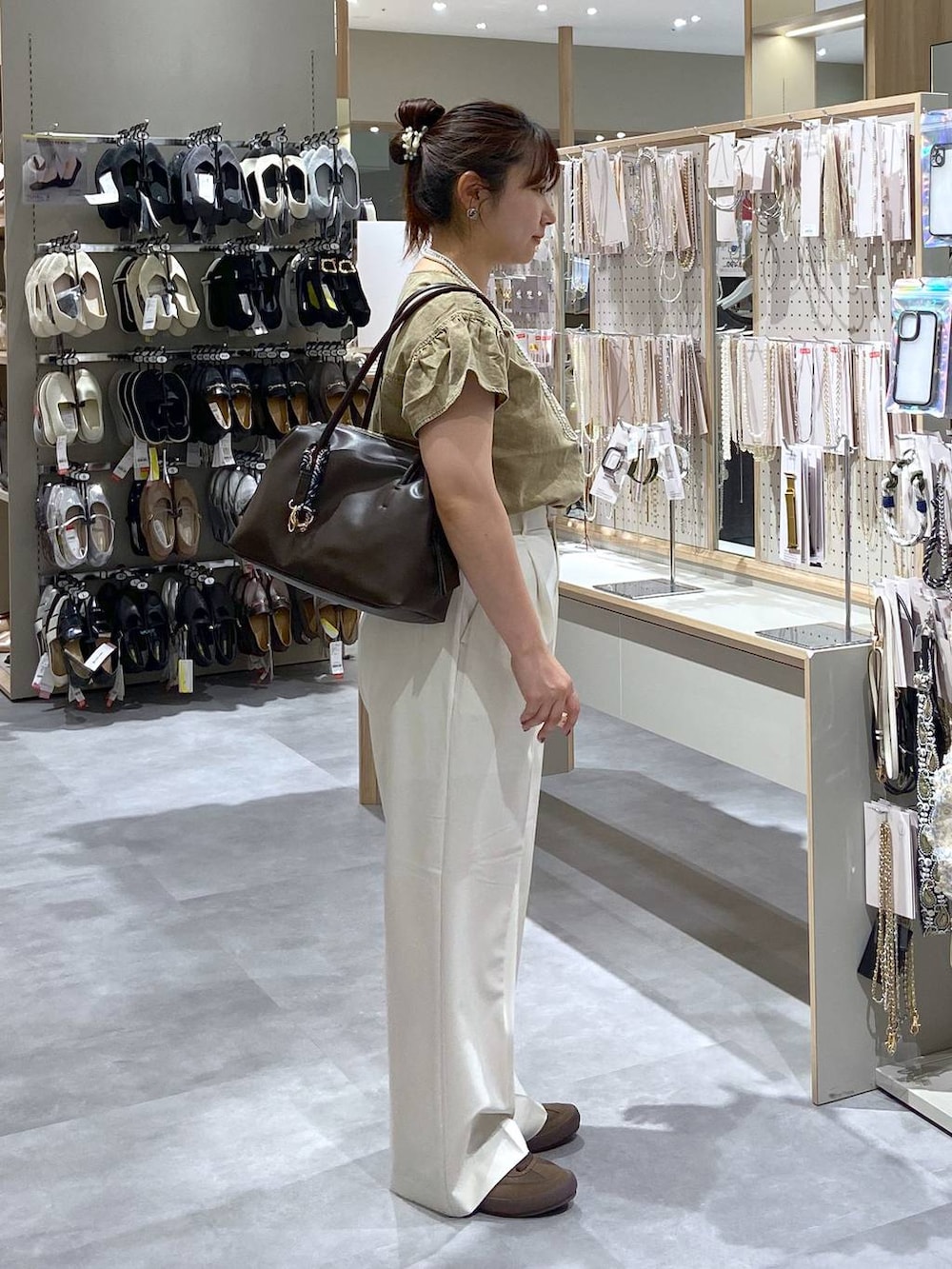 ホワイト系のその他パンツ、ブラウン系のボストンバッグ、ベージュ系のシャツ/ブラウスを着用したレディースの夏コーディネートの4枚目の写真