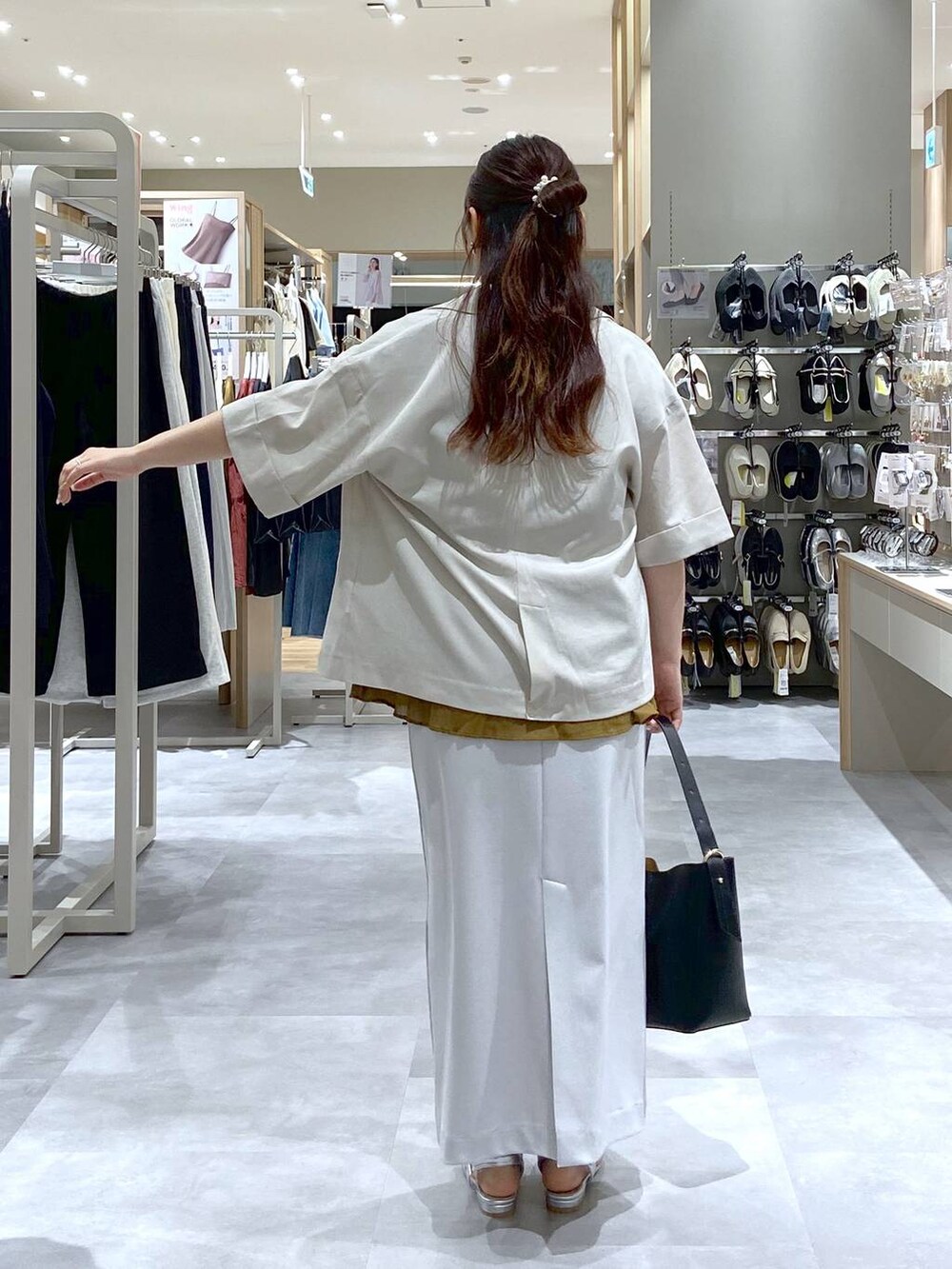 ブラック系のショルダーバッグ、シルバー系のサンダル、グレー系のスカートを着用したレディースの夏コーディネートの4枚目の写真