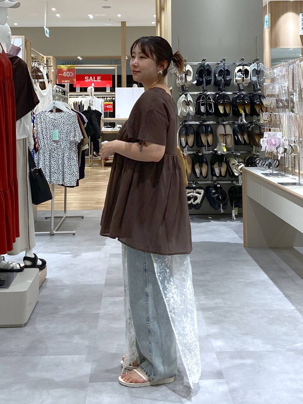 ブルー系のデニムパンツ、ブラウン系のシャツ/ブラウス、ベージュ系のサンダルを着用したレディースの夏コーディネートの2枚目の写真