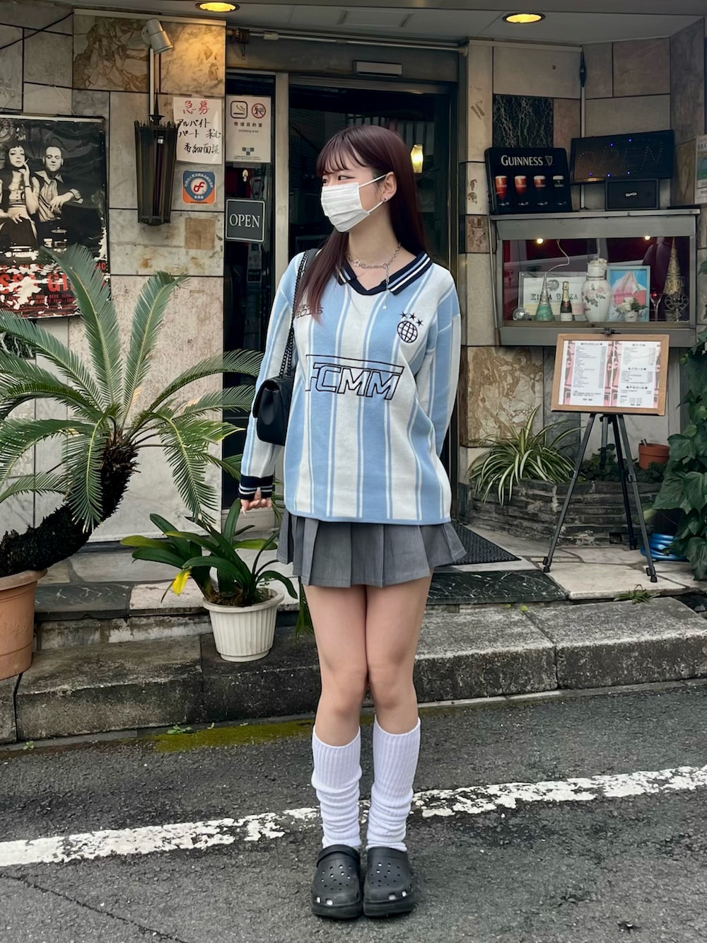 ブルー系のトップス、ブラック系のサンダル、グレー系のスカートを着用したレディースの冬コーディネートの2枚目の写真