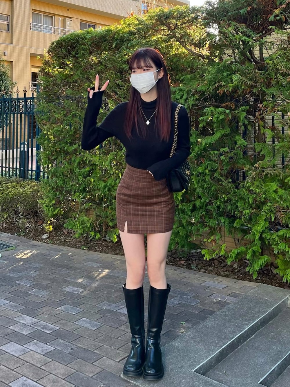 グレー系のニット/セーター、ブラック系のバッグ、ブラック系のブーツを着用したレディースの冬コーディネートの3枚目の写真