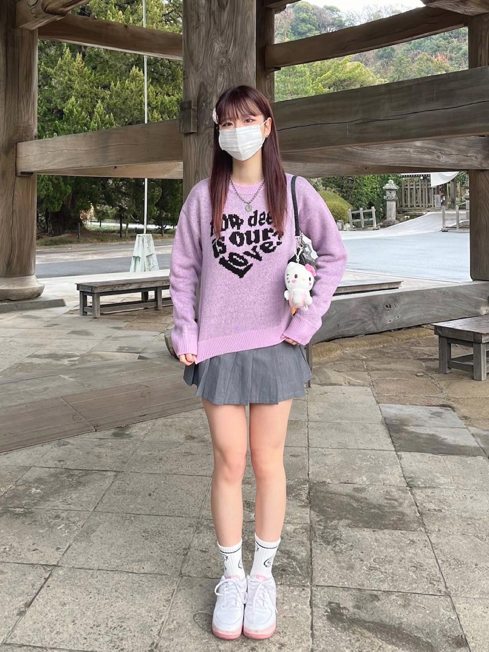 パープル系のニット/セーター、グレー系のスカート、ピンク系のスニーカーを着用したレディースの冬コーディネートの3枚目の写真