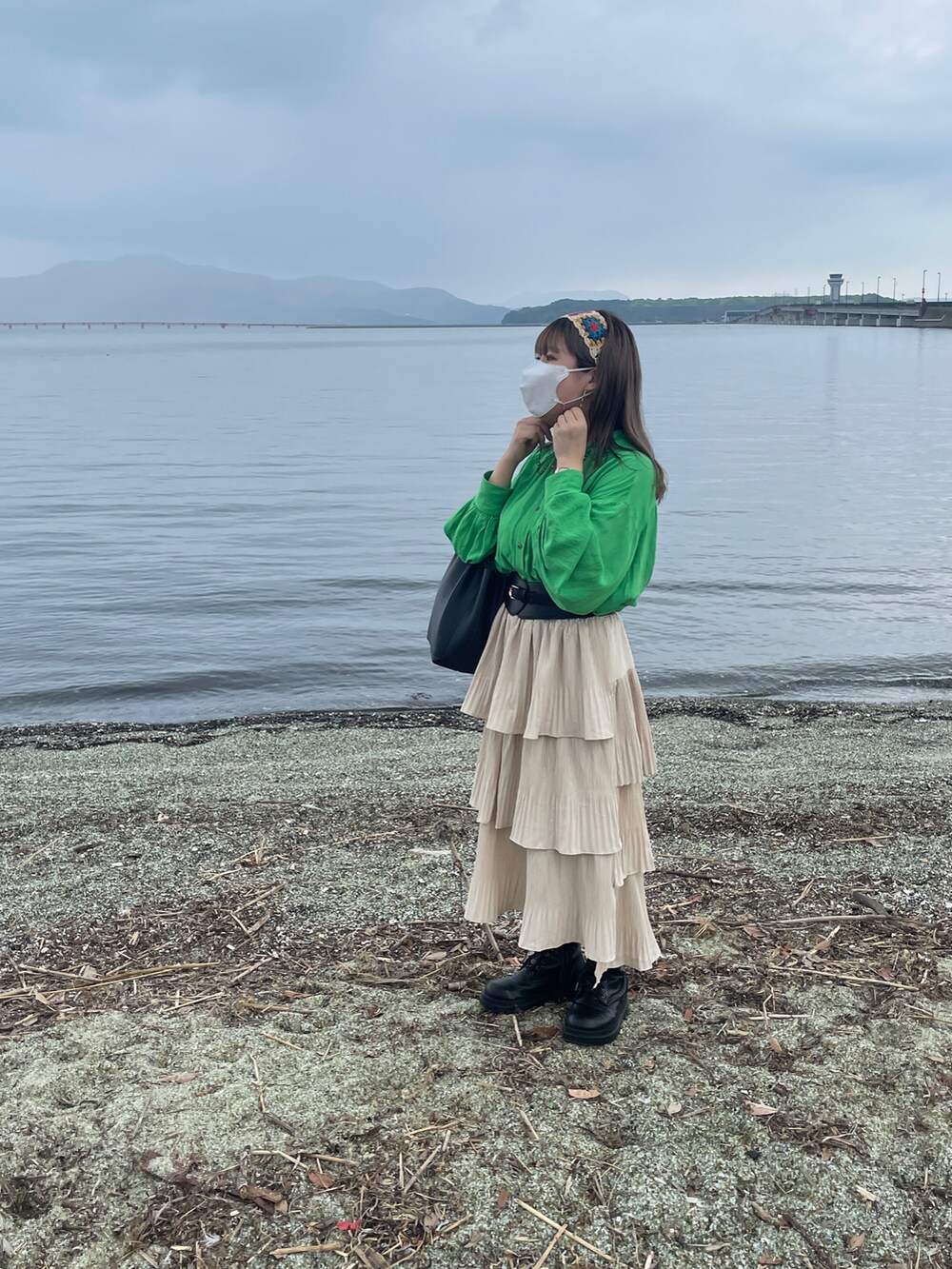 ブラック系のブーツ、ブラック系のハンドバッグ、グリーン系のシャツ/ブラウスを着用したレディースの秋コーディネートの2枚目の写真