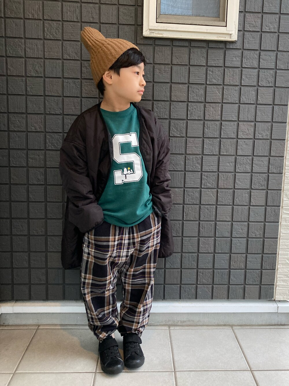 ブラック系のモッズコート、グリーン系のスウェット、ブラック系のその他パンツを着用したキッズの冬コーディネートの3枚目の写真