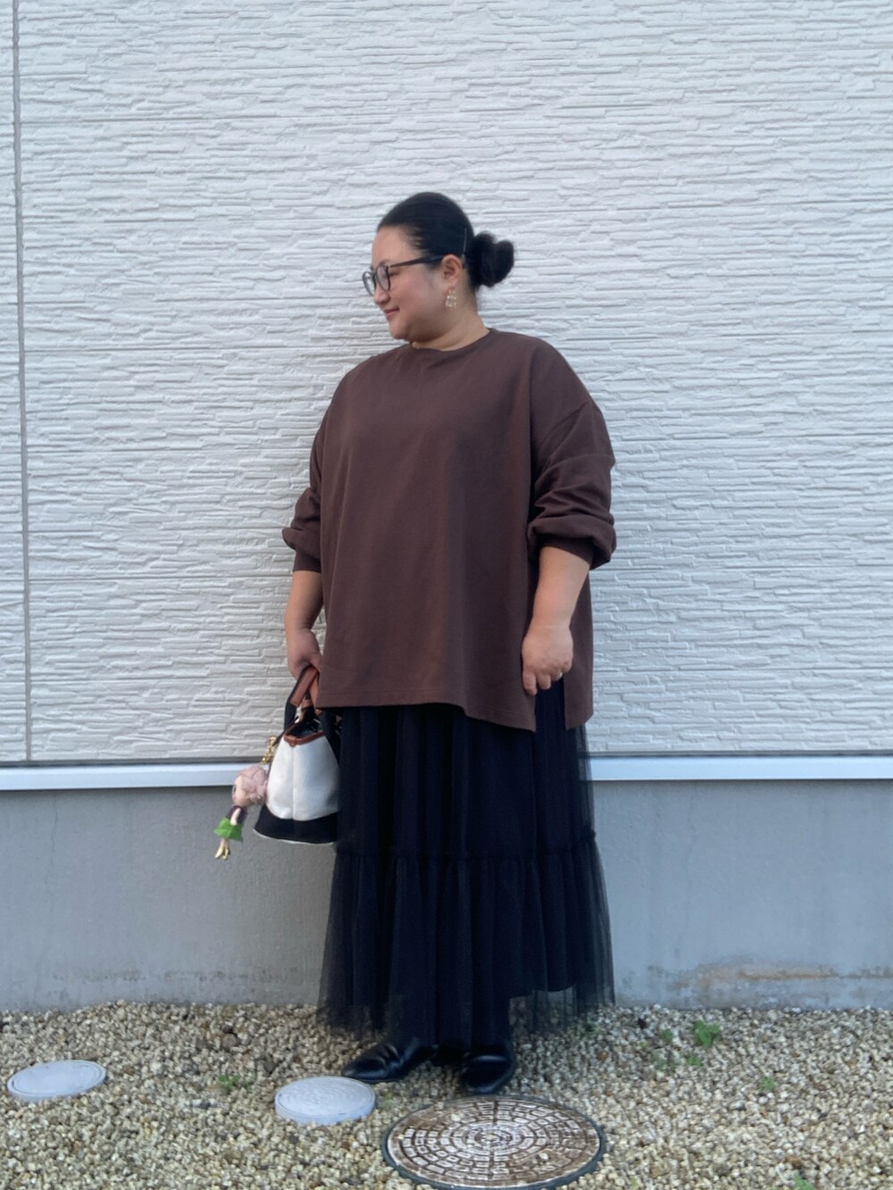 ブラウン系のTシャツ/カットソー、ブラック系のスカート、ブラック系のドレスシューズを着用したレディースの秋コーディネートの2枚目の写真