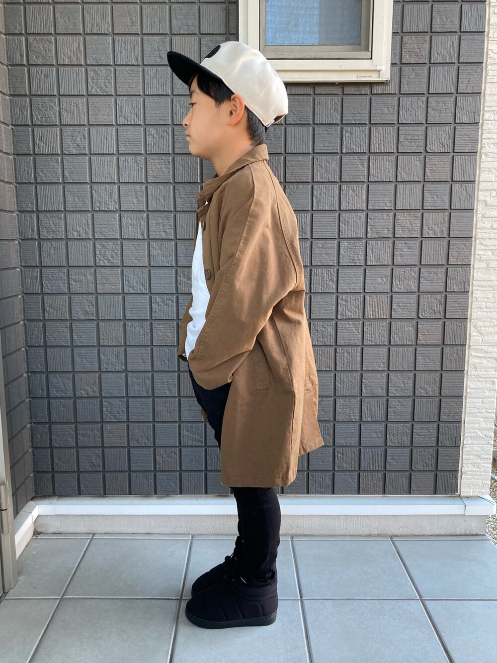 ホワイト系のTシャツ/カットソー、ブラック系のその他パンツ、ブラック系のブーツを着用したキッズの秋コーディネートの2枚目の写真