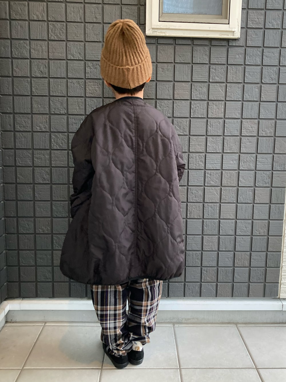 ブラック系のモッズコート、グリーン系のスウェット、ブラック系のその他パンツを着用したキッズの冬コーディネートの5枚目の写真