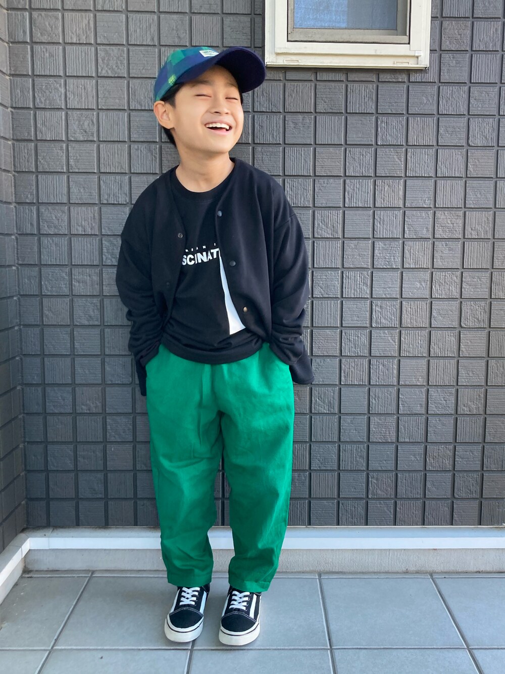 ブラック系のカーディガン/ボレロ、ブラック系のTシャツ/カットソー、グリーン系のその他パンツを着用したキッズの秋コーディネートの4枚目の写真