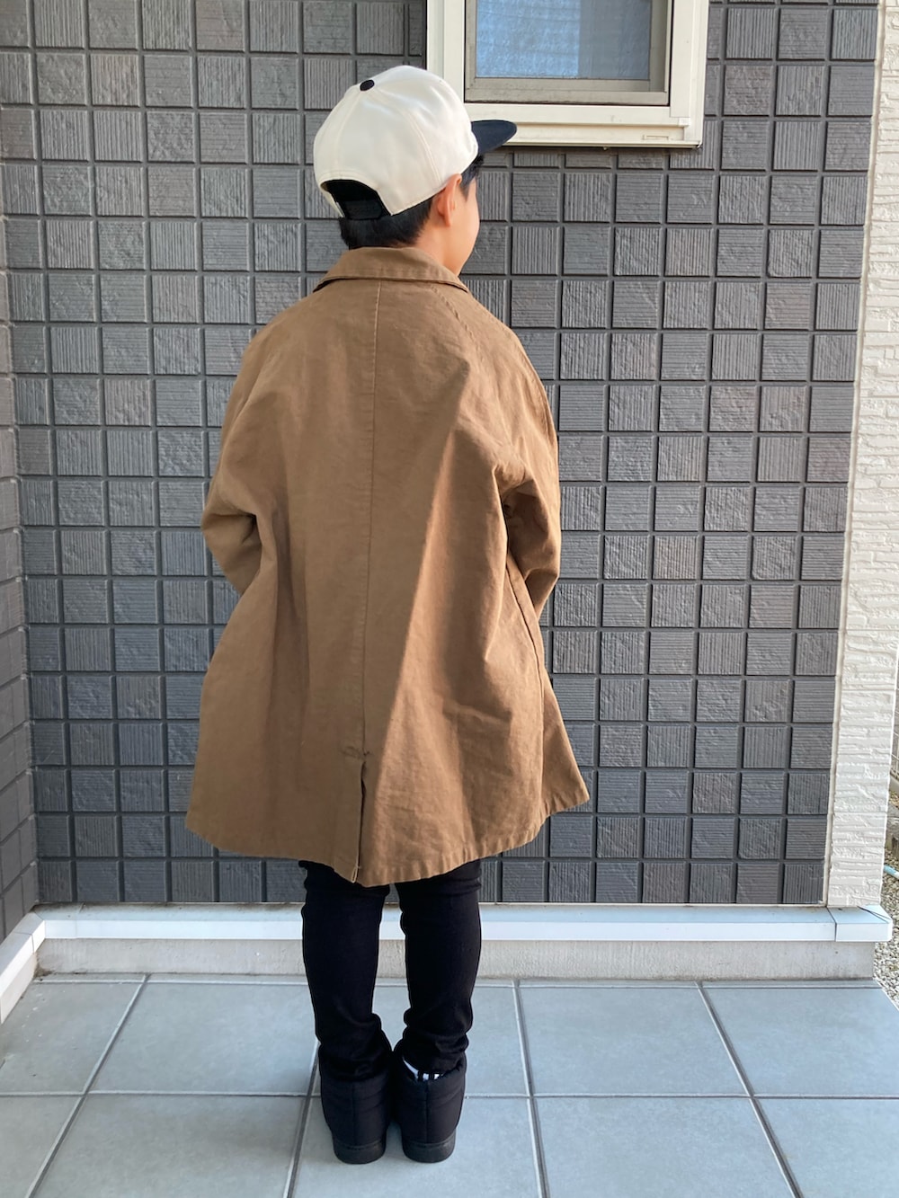 ホワイト系のTシャツ/カットソー、ブラック系のその他パンツ、ブラック系のブーツを着用したキッズの秋コーディネートの5枚目の写真