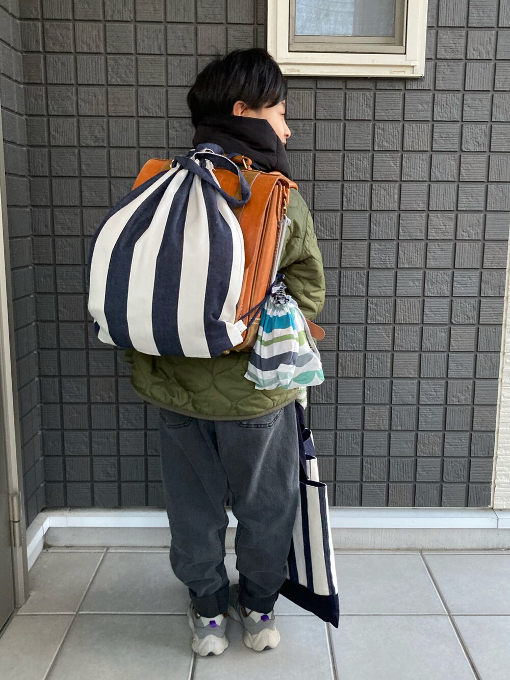 グリーン系のその他アウター、ブラウン系のスウェット、グレー系のデニムパンツを着用したキッズの冬コーディネートの5枚目の写真