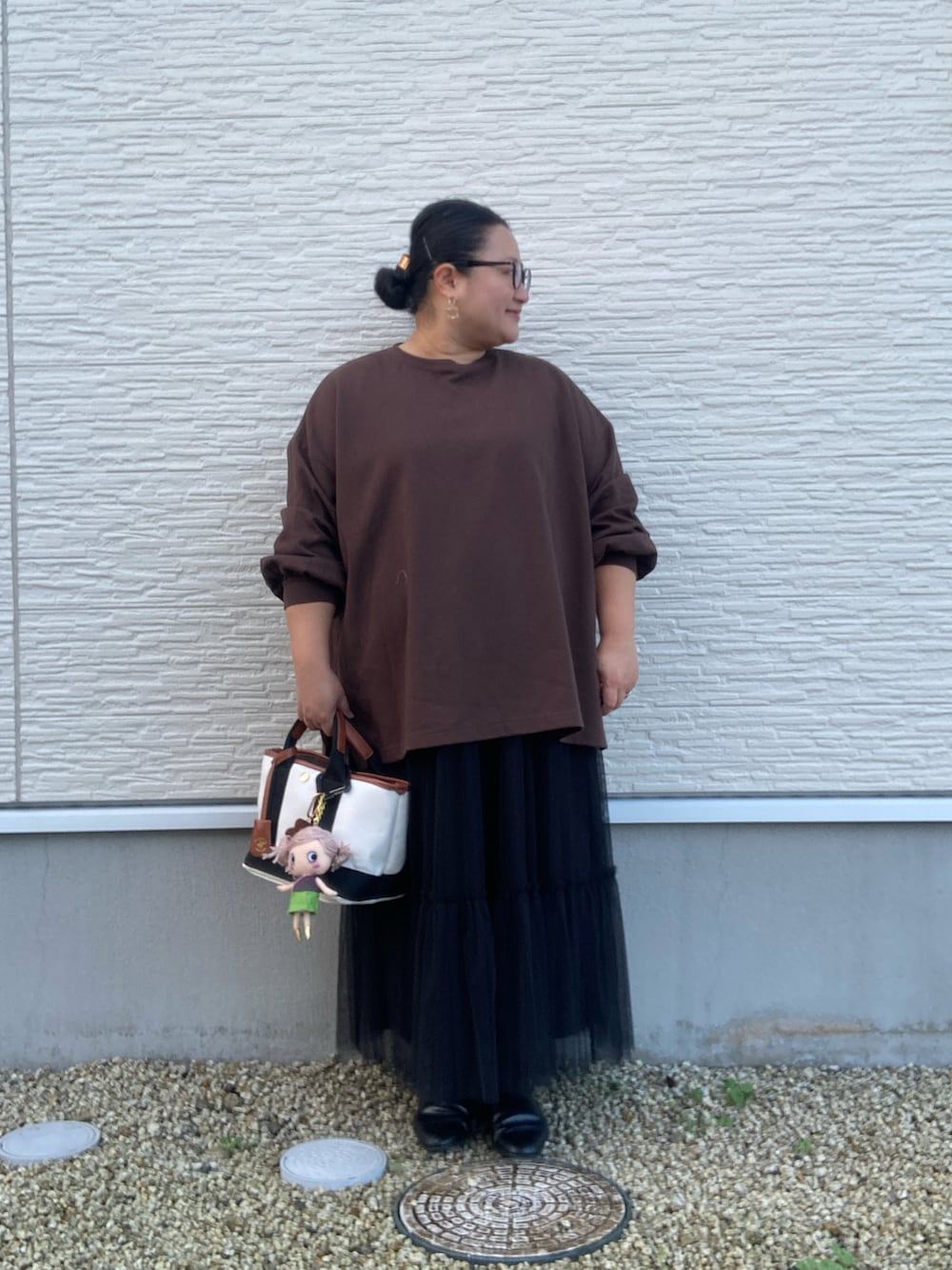 ブラウン系のTシャツ/カットソー、ブラック系のスカート、ブラック系のドレスシューズを着用したレディースの秋コーディネートの5枚目の写真