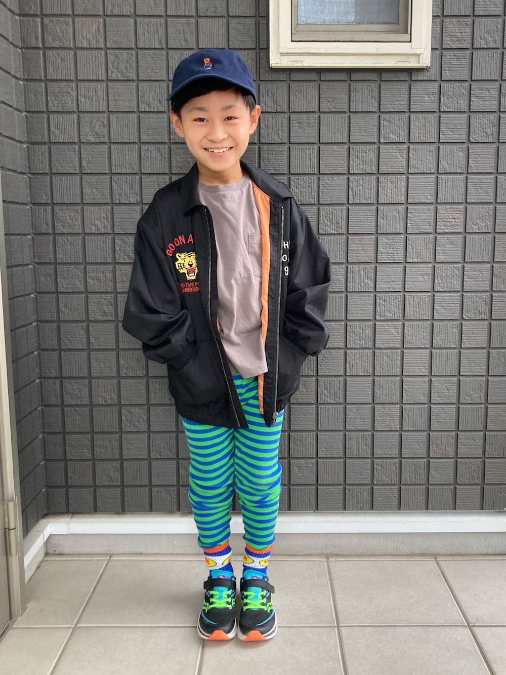 グレー系のTシャツ/カットソー、グリーン系のタンクトップ、ブラック系のスニーカーを着用したキッズの春コーディネートの4枚目の写真