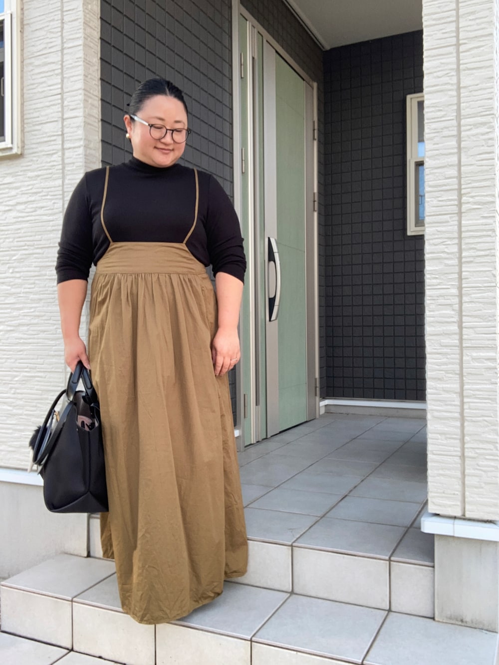 ブラック系のTシャツ/カットソー、イエロー系のワンピース、ブラック系のドレスシューズを着用したレディースの秋コーディネートの2枚目の写真