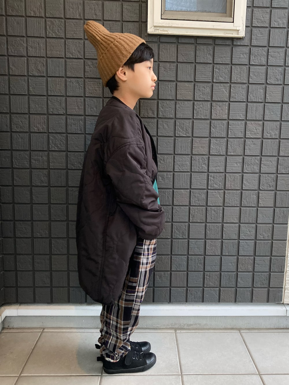 ブラック系のモッズコート、グリーン系のスウェット、ブラック系のその他パンツを着用したキッズの冬コーディネートの4枚目の写真