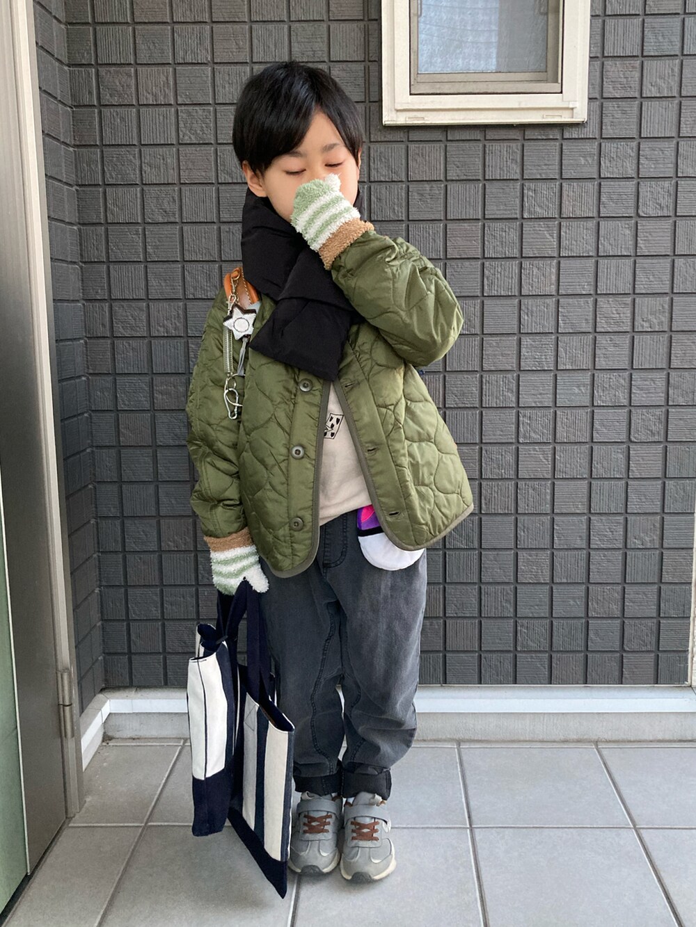 グリーン系のその他アウター、ブラウン系のスウェット、グレー系のデニムパンツを着用したキッズの冬コーディネートの4枚目の写真