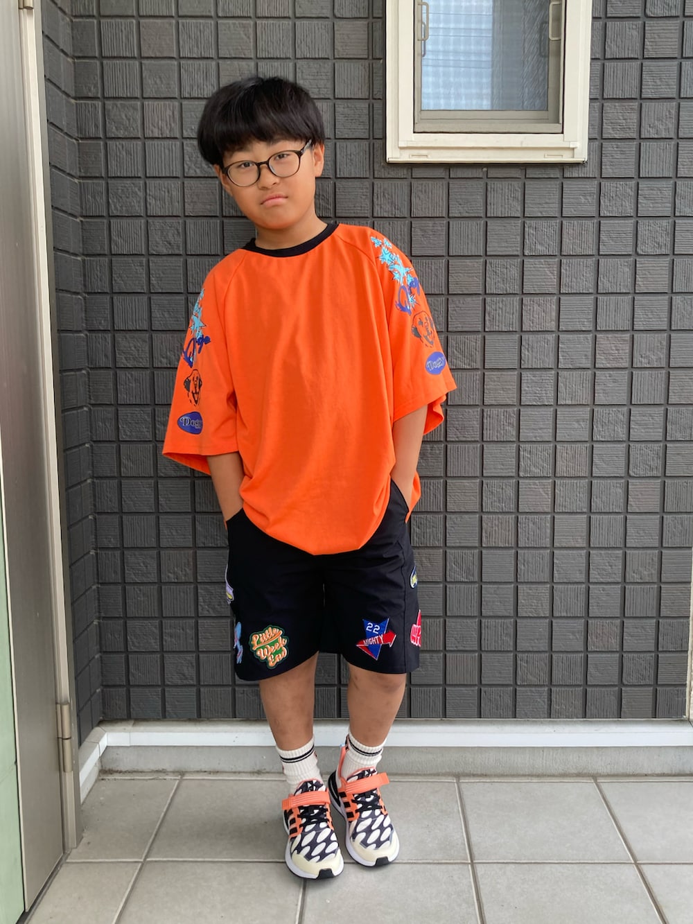 オレンジ系のTシャツ/カットソー、ブラック系のその他パンツ、ブラック系のスニーカーを着用したキッズの夏コーディネートの4枚目の写真