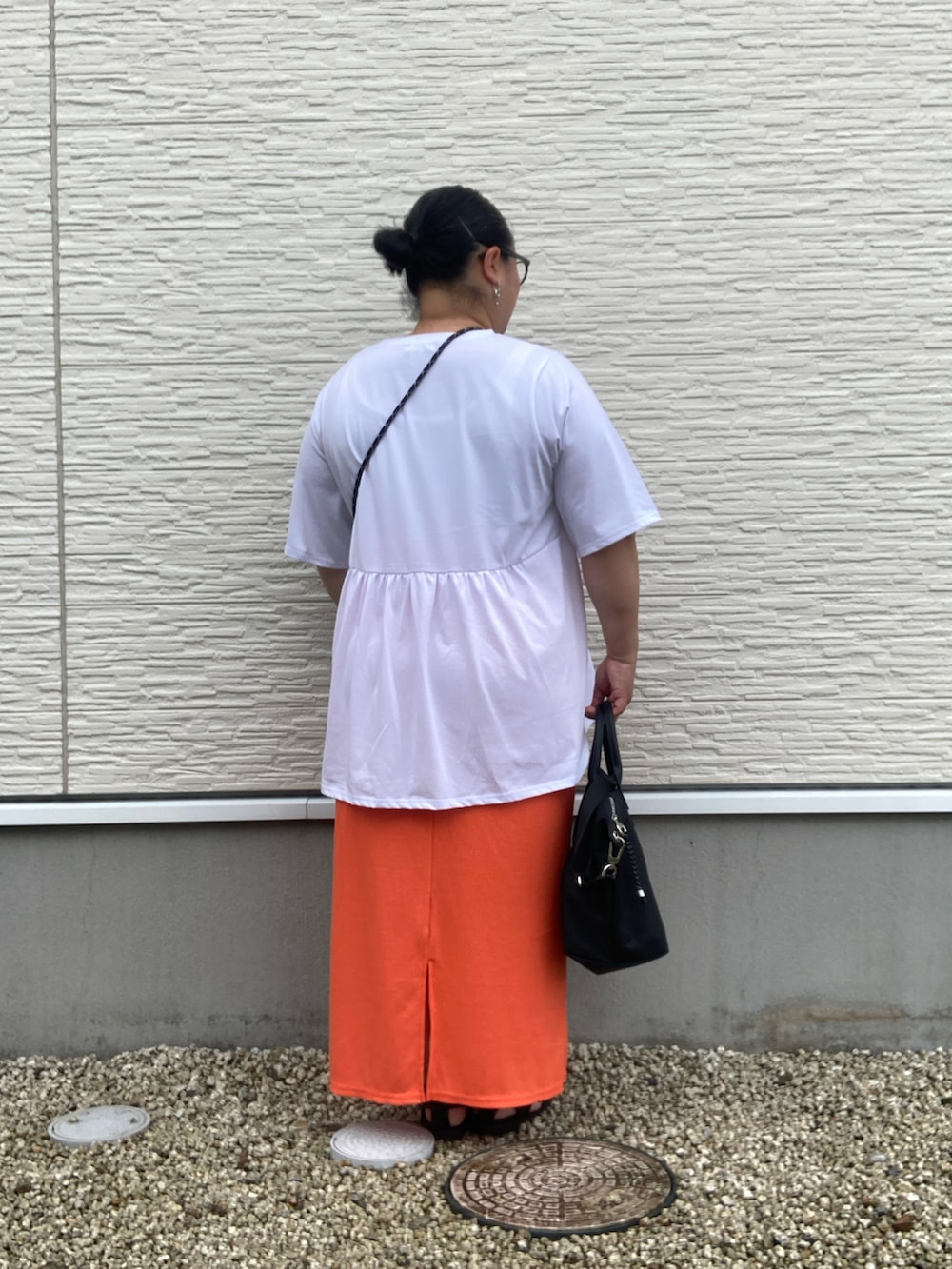 ブラック系のサンダル、ホワイト系のTシャツ/カットソー、オレンジ系のスカートを着用したレディースの夏コーディネートの4枚目の写真