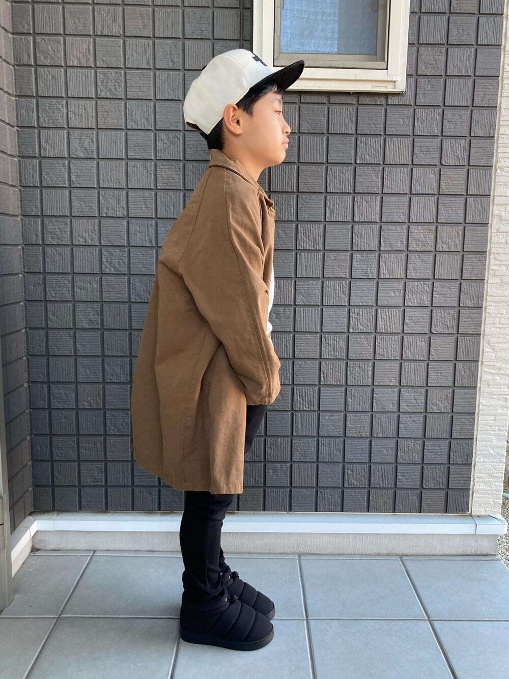 ホワイト系のTシャツ/カットソー、ブラック系のその他パンツ、ブラック系のブーツを着用したキッズの秋コーディネートの3枚目の写真