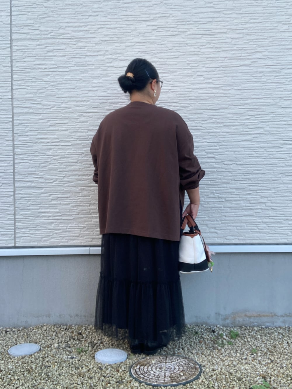 ブラウン系のTシャツ/カットソー、ブラック系のスカート、ブラック系のドレスシューズを着用したレディースの秋コーディネートの4枚目の写真