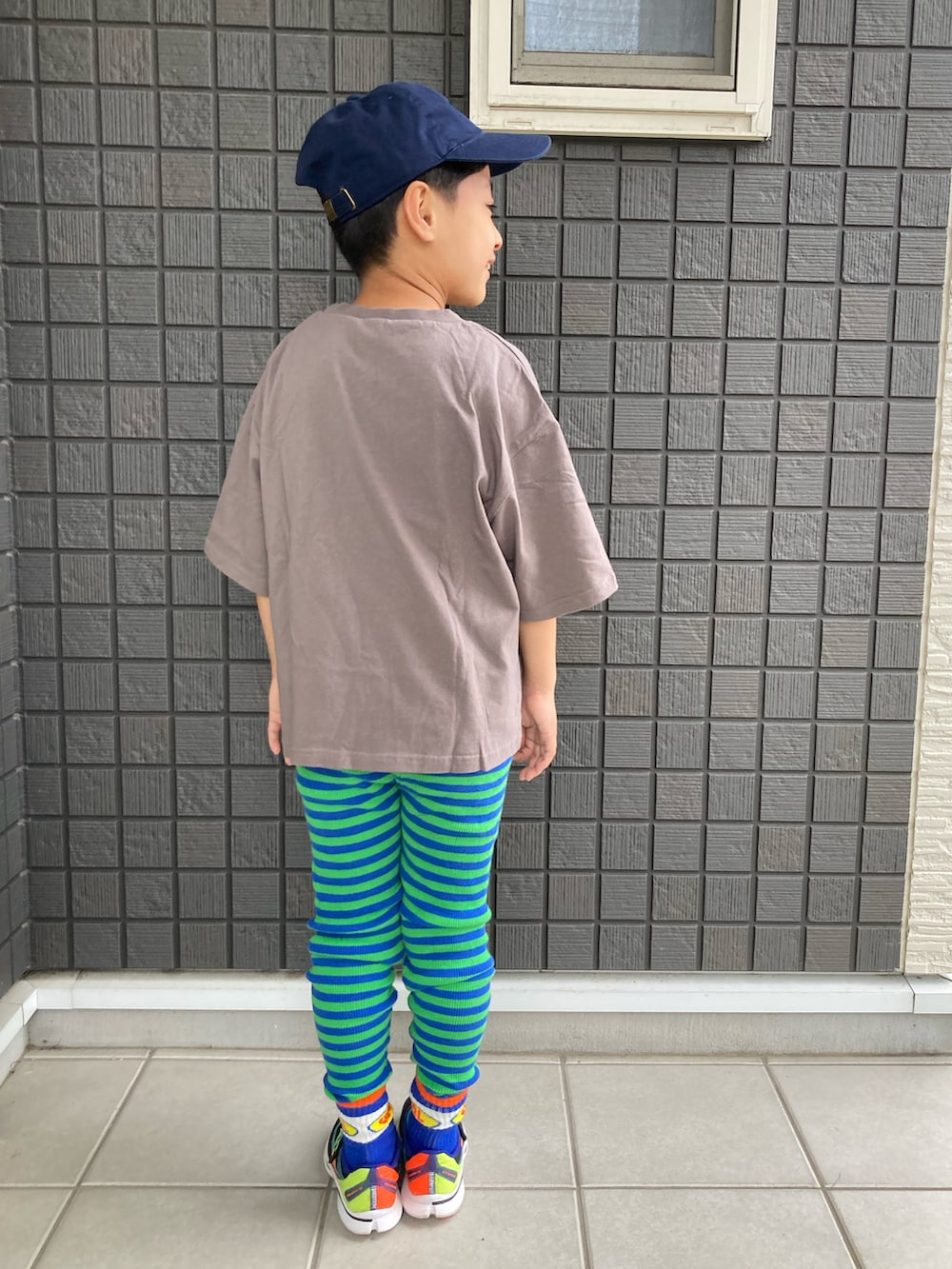 グレー系のTシャツ/カットソー、グリーン系のタンクトップ、ブラック系のスニーカーを着用したキッズの春コーディネートの3枚目の写真