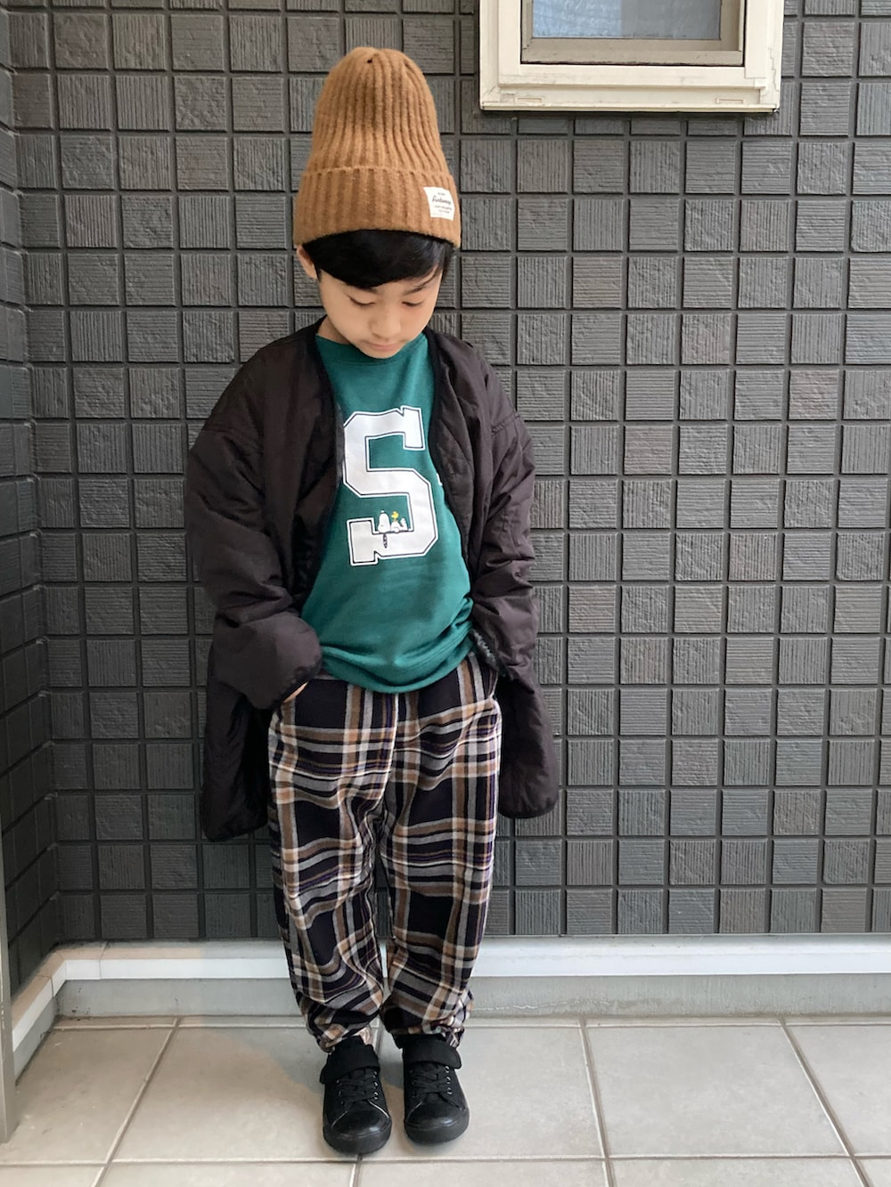 ブラック系のモッズコート、グリーン系のスウェット、ブラック系のその他パンツを着用したキッズの冬コーディネートの2枚目の写真