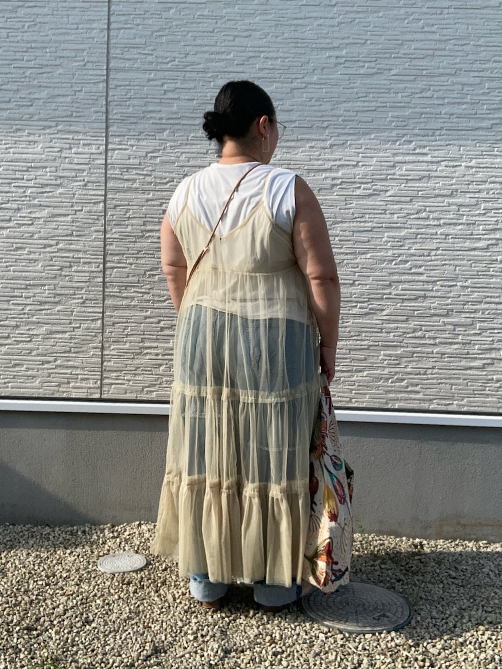 グリーン系のワンピース、ホワイト系のTシャツ/カットソー、ブルー系のデニムパンツを着用したレディースの夏コーディネートの3枚目の写真