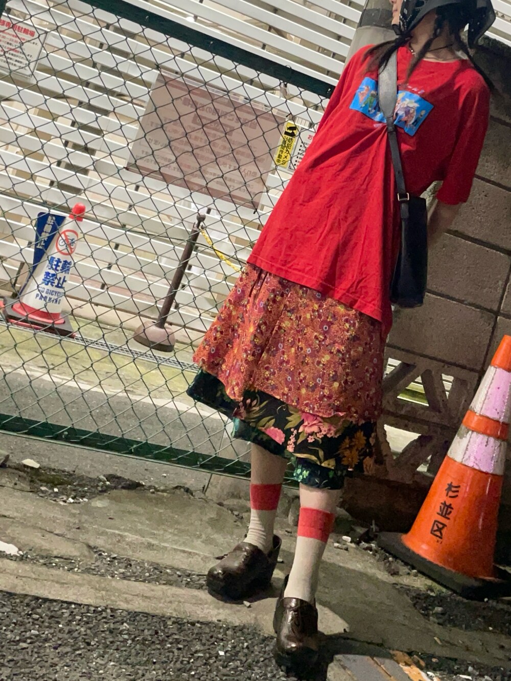 レッド系のTシャツ/カットソー、オレンジ系のスカート、ブラウン系のサンダルを着用したレディースの秋コーディネートの3枚目の写真