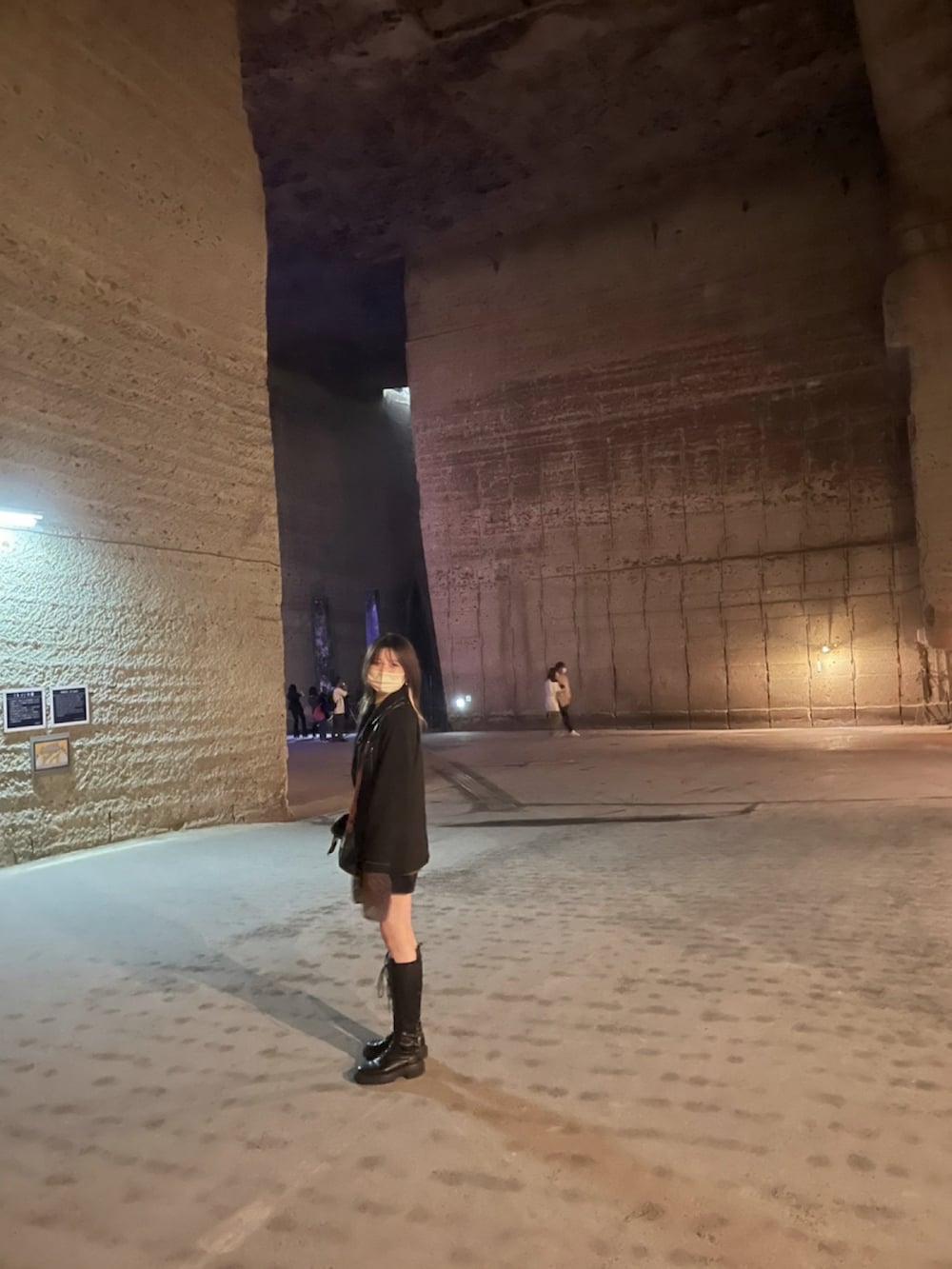 ブラック系のテーラードジャケット、ブラウン系のニット/セーター、グリーン系のショルダーバッグを着用したレディースの夏コーディネートの2枚目の写真