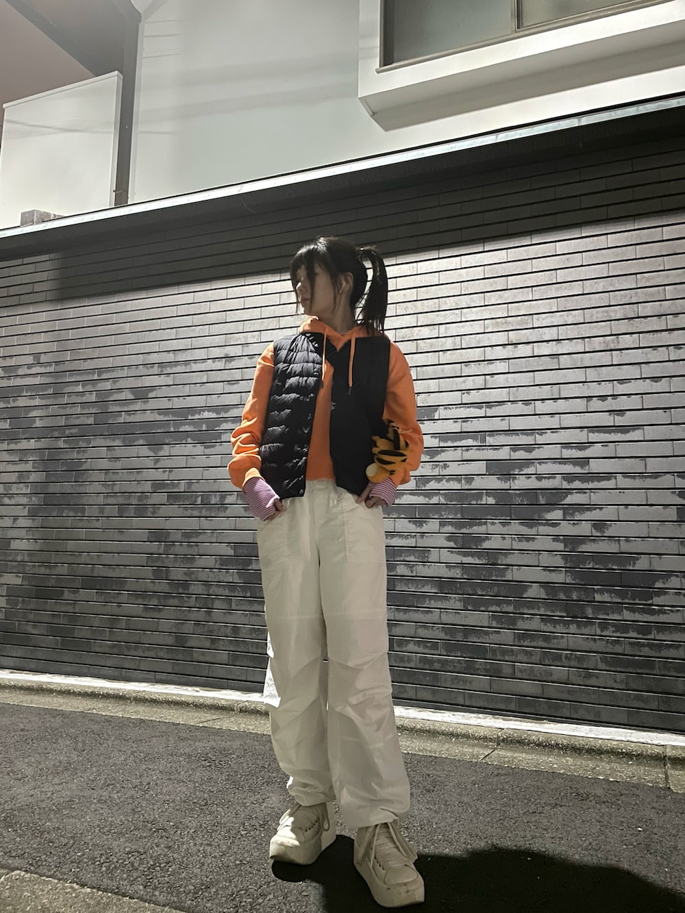 ブラック系のダウンジャケット/コート、ピンク系のTシャツ/カットソー、ホワイト系のカーゴパンツを着用したレディースの春コーディネートの2枚目の写真