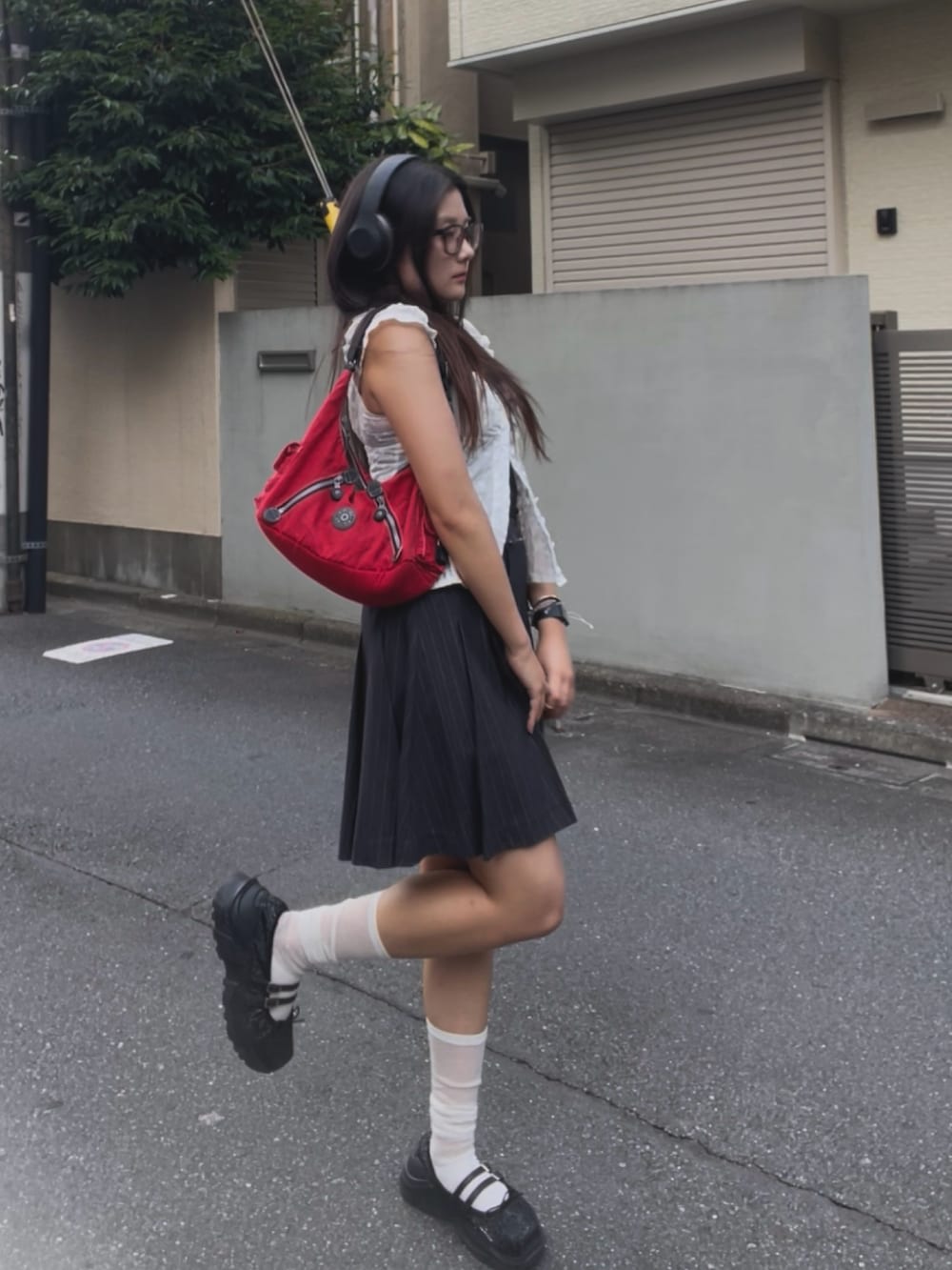 レッド系のバッグ、ホワイト系のシャツ/ブラウス、グレー系のスカートを着用したレディースの夏コーディネートの2枚目の写真