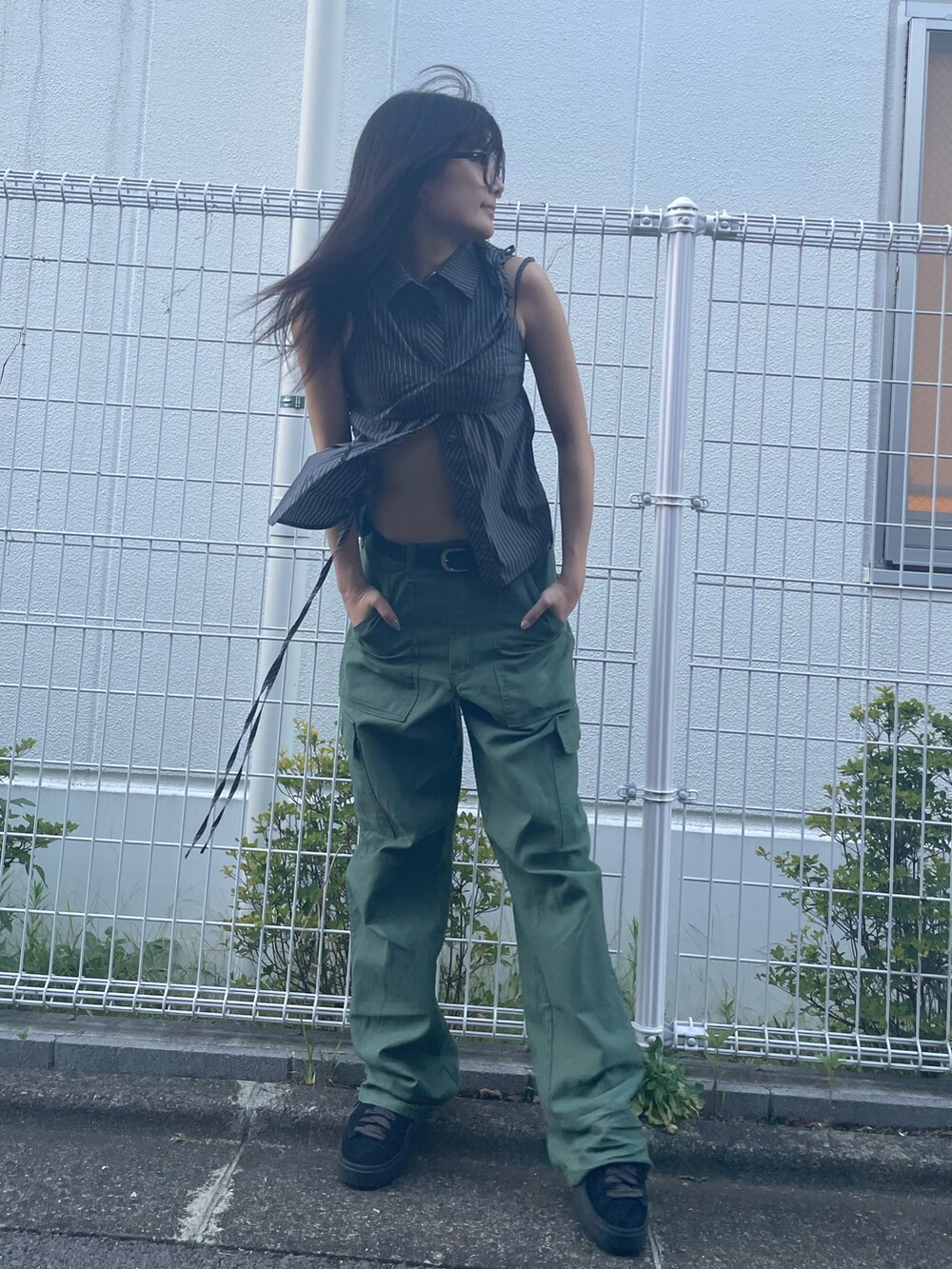 ブラック系のシャツ/ブラウス、ブラック系のベスト、グリーン系のカーゴパンツを着用したレディースの夏コーディネートの2枚目の写真