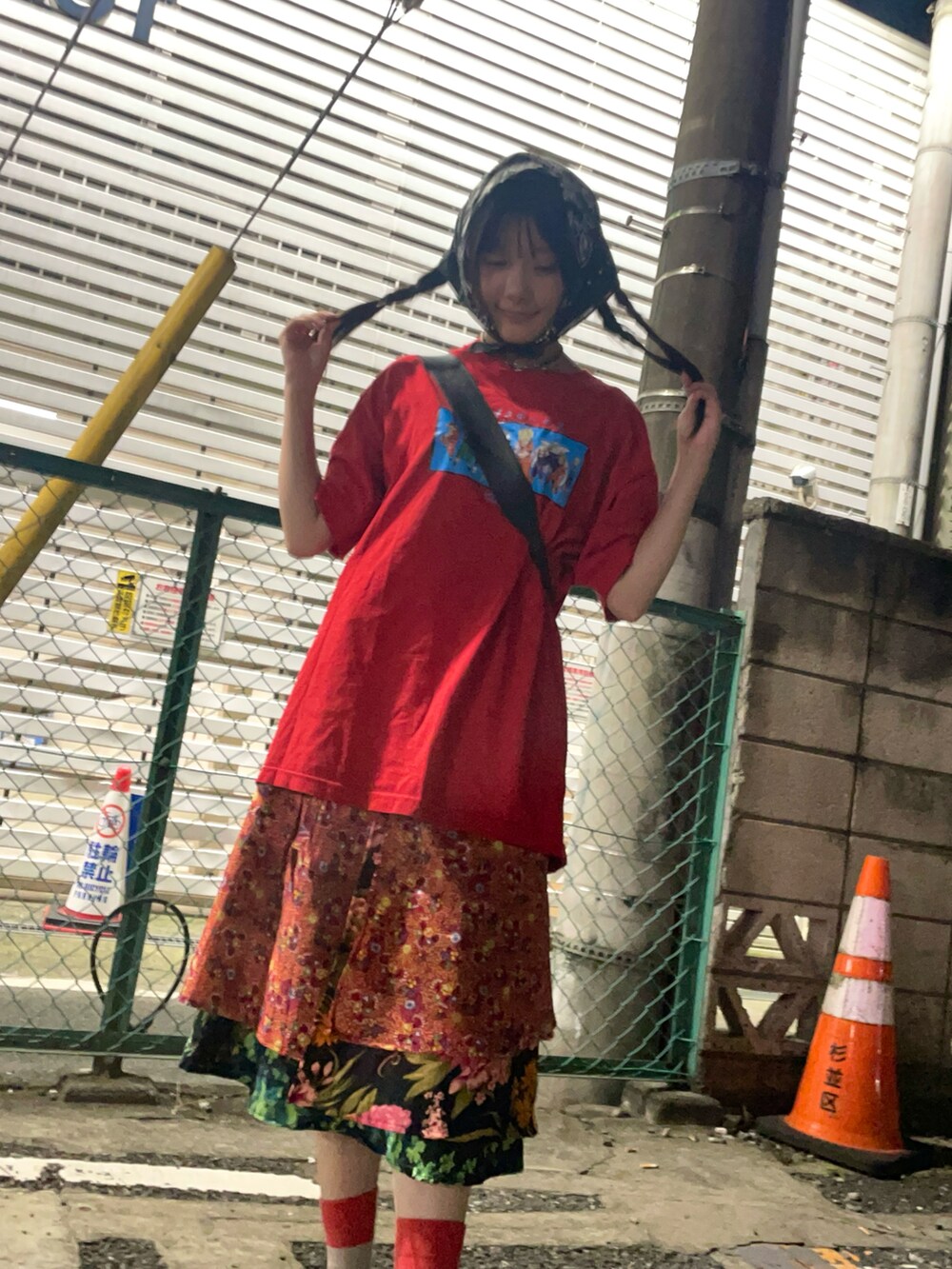 レッド系のTシャツ/カットソー、オレンジ系のスカート、ブラウン系のサンダルを着用したレディースの秋コーディネートの2枚目の写真