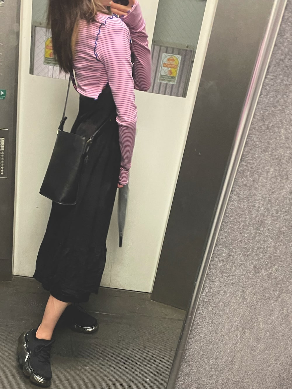 ピンク系のTシャツ/カットソー、ブラック系のワンピース、ブラック系のスニーカーを着用したレディースの秋コーディネートの2枚目の写真