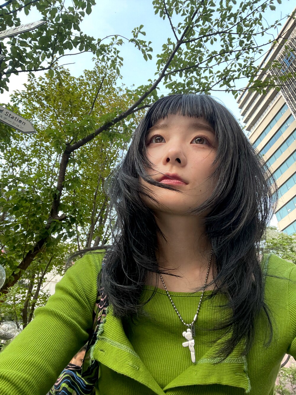 グリーン系のカーディガン/ボレロ、グリーン系のトートバッグ、ブルー系のデニムパンツを着用したレディースの春コーディネートの3枚目の写真