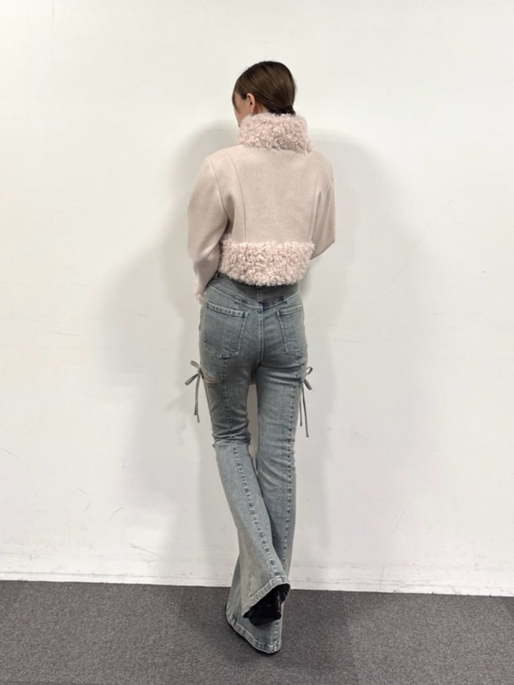 ブルー系のデニムパンツ、ブラック系のパンプス、ホワイト系のハンドバッグを着用したレディースの夏コーディネートの5枚目の写真